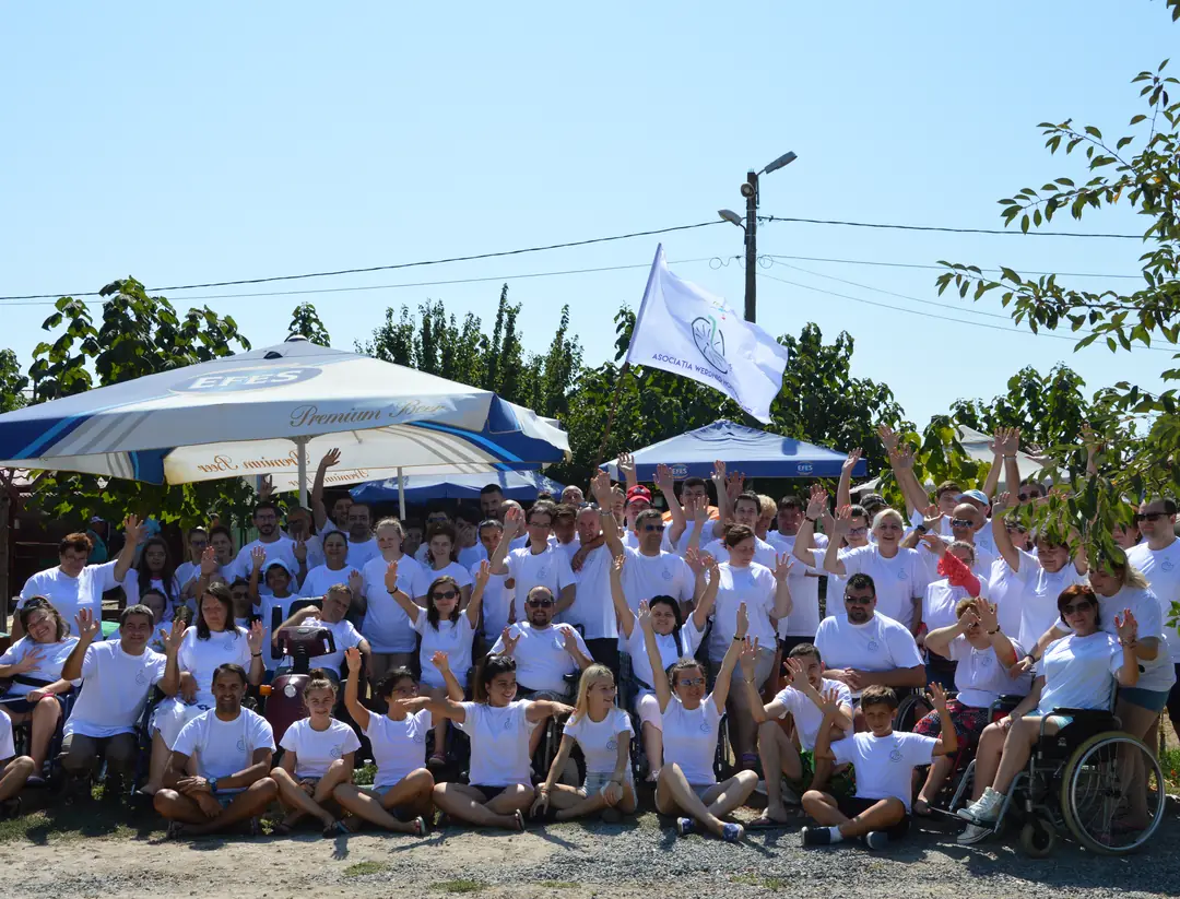 Camp participants in white T-shirts with the association's flag