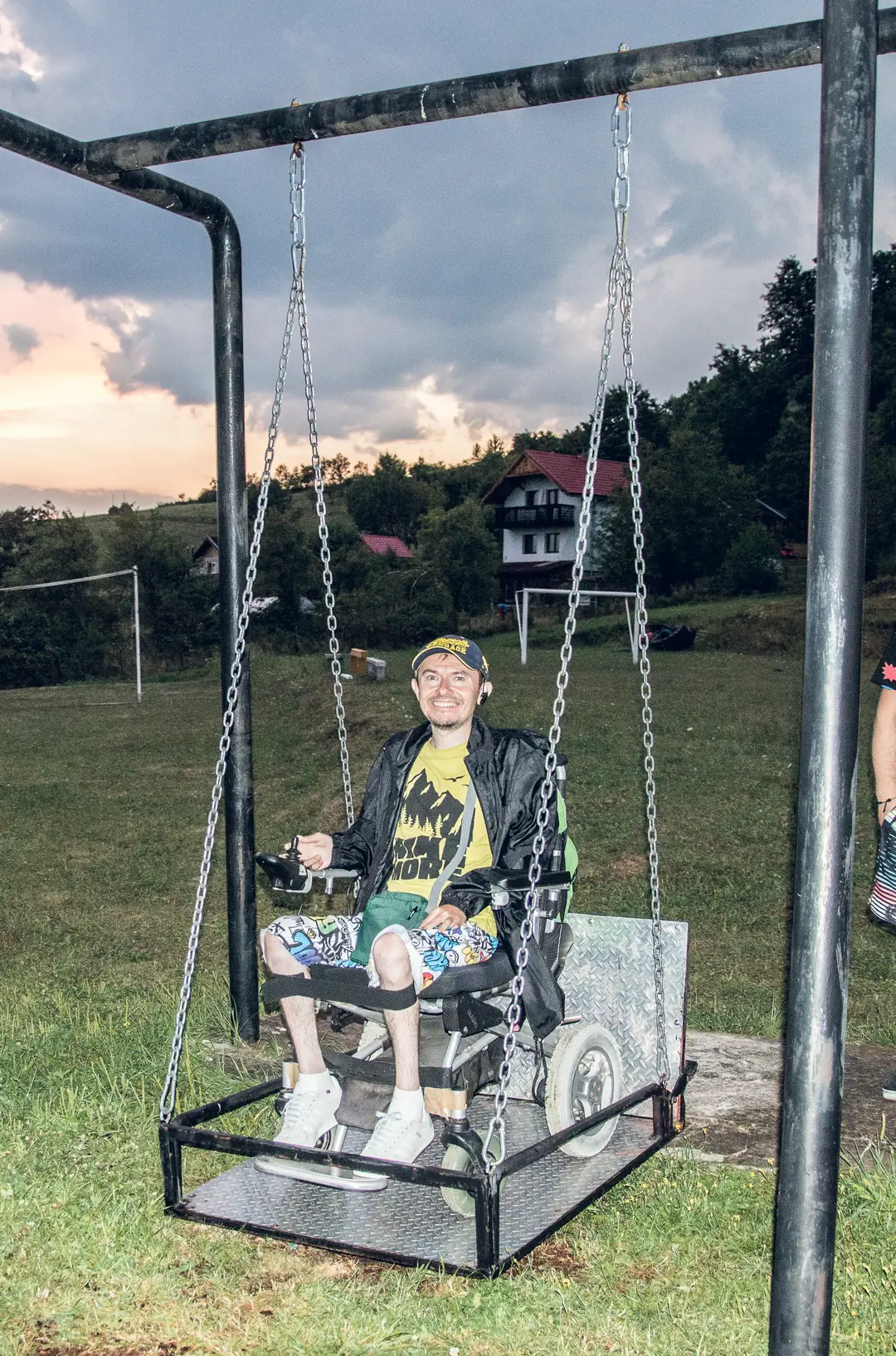 A young man in a wheelchair on the accessible swing