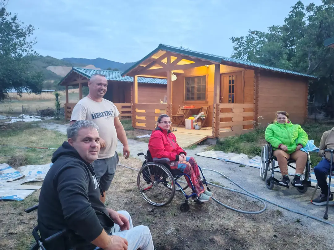 Participants in front of the wooden cabins in Pietroasa