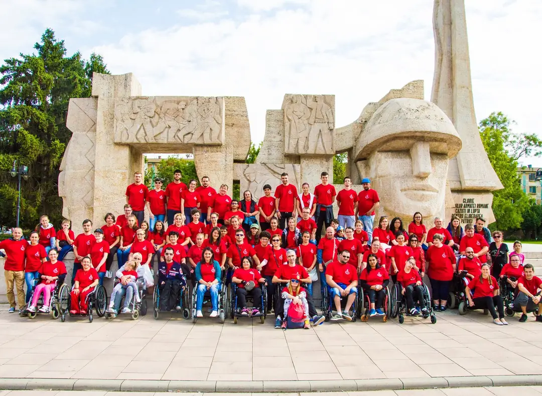 Camp participants in red T-shirts in front of the Romanian Soldier Monument in Carei